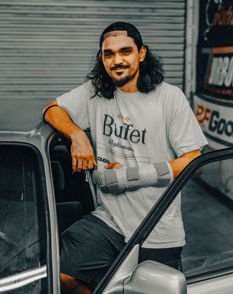 Nico D. of Car Buffet in Holly Hill, Florida, standing in the open door of his Toyota Cressida and wearing a shirt with his shop's name on it